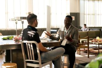 Two men sitting at a table and having a conversation